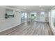 Bright sun room featuring wood look floors, natural light, and views into the kitchen at 425 Pirates Pt, North Port, FL 34287