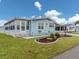 A charming home with light blue siding, complemented by a well-kept lawn and a welcoming sunroom at 443 Landsedge Dr, North Port, FL 34287