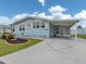 Charming single-story home with light blue siding, complemented by a well-maintained lawn and covered parking at 443 Landsedge Dr, North Port, FL 34287