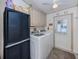 Efficient laundry room with modern appliances, storage, and a ceiling fan at 443 Landsedge Dr, North Port, FL 34287