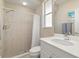 Bathroom with tiled walk-in shower, white sink vanity, and soft natural light at 4641 Gaeta Dr, Venice, FL 34293
