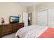 Relaxing bedroom with a dresser, TV, and access to an adjacent room, plus two closets at 4641 Gaeta Dr, Venice, FL 34293