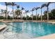 Relaxing community pool with palm trees, comfortable seating, and pristine blue water at 4641 Gaeta Dr, Venice, FL 34293
