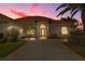Stunning property with lush landscaping, well-lit entry, and beautiful terracotta tiled roof at sunset at 4641 Gaeta Dr, Venice, FL 34293