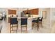 Open kitchen featuring bar-style seating, dark wood cabinets, and modern appliances, seamlessly connecting to the living space at 4641 Gaeta Dr, Venice, FL 34293