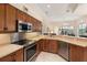 Well-lit kitchen featuring stainless steel appliances, light countertops, and a view into the living area, making it great for entertaining at 4641 Gaeta Dr, Venice, FL 34293