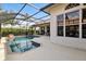 Screened-in pool area with outdoor seating, lush landscaping, and tiled pool at 4641 Gaeta Dr, Venice, FL 34293