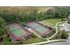 Aerial view of well-maintained tennis and bocce ball courts within a lush, green community at 4641 Gaeta Dr, Venice, FL 34293