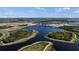 Panoramic aerial shot of a lake surrounded by green spaces, walking paths, and residential developments at 511 Porpoise Rd, Venice, FL 34293