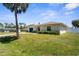 Charming single-story home featuring well-manicured lawn, arched windows, and a blue garage door at 511 Porpoise Rd, Venice, FL 34293