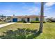 Inviting home exterior with a blue garage door, front yard landscaping, and a well-manicured lawn at 511 Porpoise Rd, Venice, FL 34293
