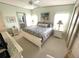 Inviting bedroom featuring a large bed, ceiling fan, soft lighting, and an ensuite bath for added convenience at 537 Amberjack Dr, North Port, FL 34287