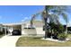Exterior of a house with well maintained landscaping, driveway, and car in the car port at 537 Amberjack Dr, North Port, FL 34287