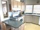 Bright kitchen features tile countertops, white appliances, and a breakfast bar that connects to another room at 537 Amberjack Dr, North Port, FL 34287