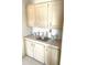Kitchenette includes upper and lower cabinets with neutral countertops and decorative accents at 537 Amberjack Dr, North Port, FL 34287