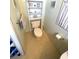 A toilet and small shelving unit with coastal decorations, next to a towel rack and window at 537 Amberjack Dr, North Port, FL 34287