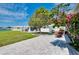 Spacious backyard with a stone patio, lush lawn, and mature trees, ideal for outdoor entertaining at 553 Circlewood Dr # T11, Venice, FL 34293