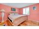 Cozy bedroom with hardwood floors, natural light, and decorative artwork at 553 Circlewood Dr # T11, Venice, FL 34293