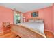 Bright bedroom with a light wood bed frame and colorful patterned bedding, complemented by a serene peacock artwork at 553 Circlewood Dr # T11, Venice, FL 34293