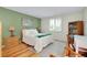 Comfortable bedroom featuring a large window, hardwood floors, and green accent wall at 553 Circlewood Dr # T11, Venice, FL 34293