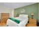 Relaxing bedroom with natural light, hardwood floors, side tables, and a green accent wall at 553 Circlewood Dr # T11, Venice, FL 34293