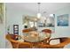 Bright dining area featuring a glass table, wicker chairs, and seamless access to the kitchen at 553 Circlewood Dr # T11, Venice, FL 34293