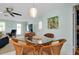Inviting dining area with a glass table, wicker chairs, and an open view of the living room at 553 Circlewood Dr # T11, Venice, FL 34293