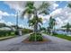 Well-manicured community entrance featuring lush landscaping and a prominent palm tree, creating a welcoming first impression at 553 Circlewood Dr # T11, Venice, FL 34293