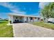 Attractive home with a brick driveway, carport, and lush front lawn, providing a warm welcome at 553 Circlewood Dr # T11, Venice, FL 34293