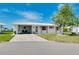Inviting home with a neatly paved driveway, covered carport, and well-kept front yard, showcasing its charm at 553 Circlewood Dr # T11, Venice, FL 34293