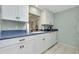 Bright kitchen featuring white cabinetry and blue countertops with modern appliances at 553 Circlewood Dr # T11, Venice, FL 34293