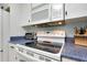 Close up on a white stove with a glass top, showcasing clean, blue-speckled countertops at 553 Circlewood Dr # T11, Venice, FL 34293