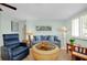 Comfortable living room with a blue sofa, recliner, and a round wicker coffee table at 553 Circlewood Dr # T11, Venice, FL 34293