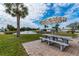 Scenic picnic area with a table and umbrella by a tranquil pond, ideal for outdoor dining and relaxation at 553 Circlewood Dr # T11, Venice, FL 34293