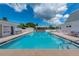Community pool with plenty of lounge chairs, and manicured grounds at 553 Circlewood Dr # T11, Venice, FL 34293