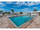 Inviting pool area surrounded by lounge chairs and palm trees under a sunny sky at 553 Circlewood Dr # T11, Venice, FL 34293