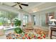 Bright sunroom featuring tile floors, ceiling fan, large windows, and access to the outdoor patio at 553 Circlewood Dr # T11, Venice, FL 34293
