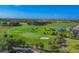 Expansive golf course with sand traps and golfers in view from above at 5641 Hidden Oak Ct, North Port, FL 34287