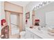 Comfortable bathroom features a shower, bath, vanity, large mirror, and excellent lighting at 5641 Hidden Oak Ct, North Port, FL 34287