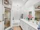 Bright bathroom features a double vanity, shower, and a separate tub beneath a chandelier at 5641 Hidden Oak Ct, North Port, FL 34287