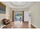 Inviting bedroom with tray ceilings, hardwood floors, and large sliding doors to the lanai at 5641 Hidden Oak Ct, North Port, FL 34287