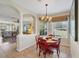Cozy dining area with a chandelier, offering views of the backyard and open to living room at 5641 Hidden Oak Ct, North Port, FL 34287