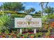 The Heron Creek Golf & Country Club sign surrounded by colorful flowers and manicured landscaping at 5641 Hidden Oak Ct, North Port, FL 34287