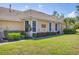 A tan home with white trim, a tile roof, and well-maintained landscaping at 5641 Hidden Oak Ct, North Port, FL 34287