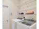 Well-equipped laundry room with modern washer, dryer, and convenient shelving at 5641 Hidden Oak Ct, North Port, FL 34287
