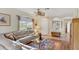Bright living room with a large window, ceiling fan, comfortable seating, and stylish decor at 5641 Hidden Oak Ct, North Port, FL 34287