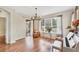 Bright living room with laminate flooring, chandelier, large windows, and a piano at 5641 Hidden Oak Ct, North Port, FL 34287