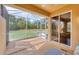 A bright, airy screened lanai with tan flooring and sliding door access to the outdoors at 5641 Hidden Oak Ct, North Port, FL 34287