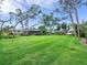 Expansive backyard with lush lawn and mature trees, perfect for outdoor activities at 608 Apalachicola Rd, Venice, FL 34285