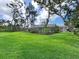 Expansive backyard featuring mature trees and a screened lanai, perfect for outdoor enjoyment at 608 Apalachicola Rd, Venice, FL 34285